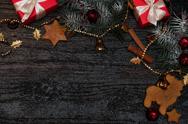 Fond sombre de Noël avec décoration festive, biscuits, pain d'épice et branches d'épinette vue de dessus, espace pour le texte — Photo