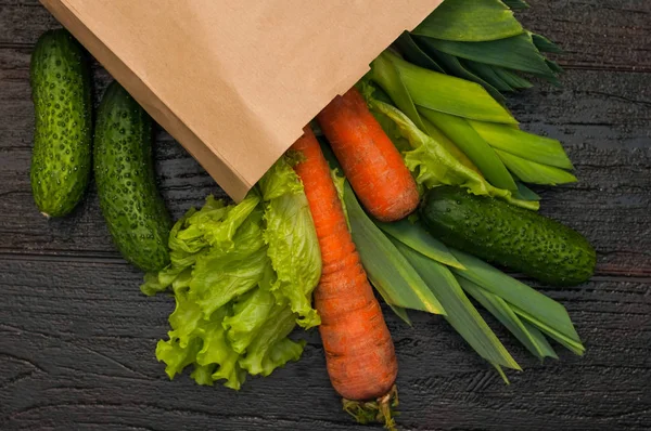 organic vegetables. bag of products on a dark wooden background. Crop agronomist from the garden. Fresh vegetables in the bag, healthy food for vegetarians