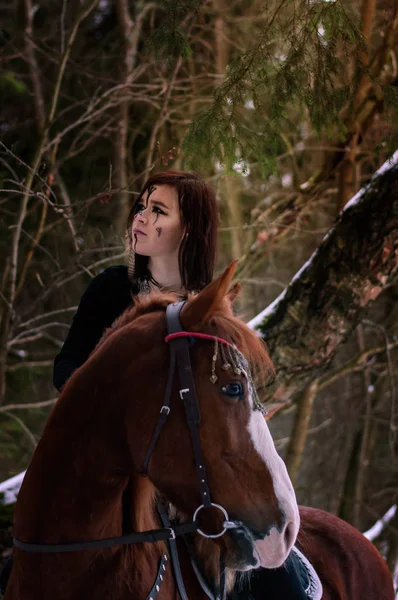 Девушка-викинг верхом на красной лошади, раскрашенной в черные руны — стоковое фото