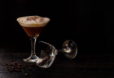 Siyah arka planda martini bardağı ve Baileys. Yanında kırık bir cam var. Tasarımcılar için yatay pankart