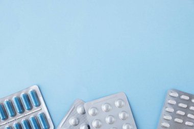 Tıbbi konu. Mavi arkaplandaki yazı için yeri olan pankart. Bir pakette mavi ve beyaz tabletler