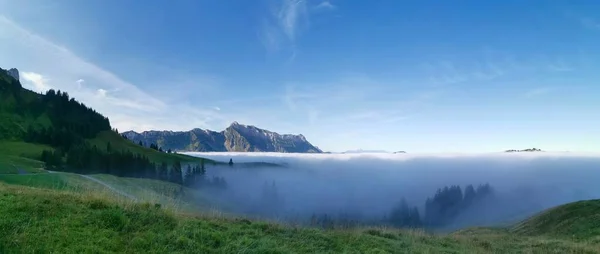 Горные вершины, выглядывающие из моря тумана — стоковое фото