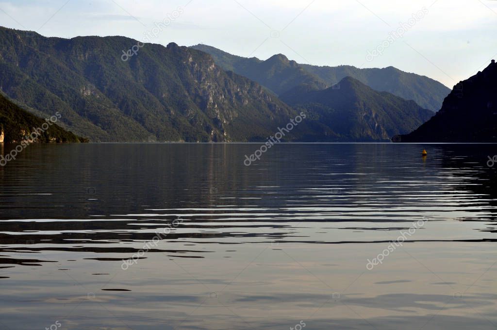 The morning light is reflected on the calm waters of the small lake