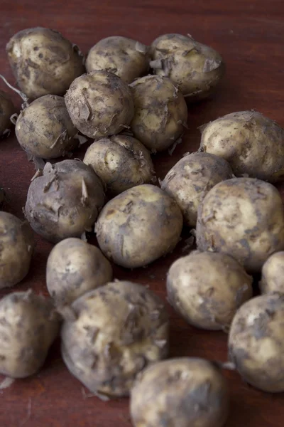 Batatas jovens na mesa de madeira — Fotografia de Stock