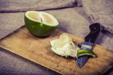 Bıçak ile ahşap arka plan üzerinde tatlı yeşil greyfurt