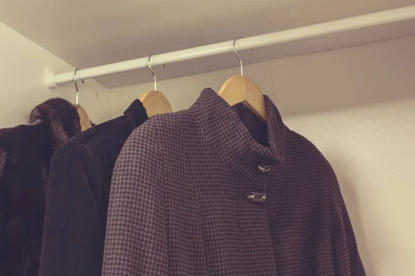 Casacos de inverno e outono pendurados no armário — Fotografia de Stock