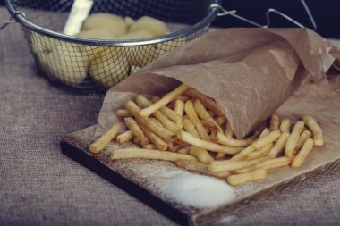 Tahta arka planda ketçaplı taze kızarmış patates kızartması.