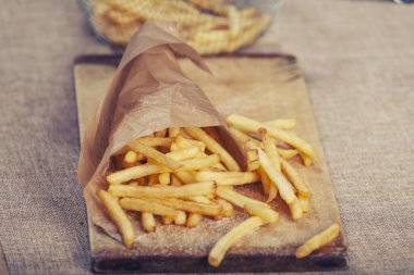 Tahta arka planda ketçaplı taze kızarmış patates kızartması.