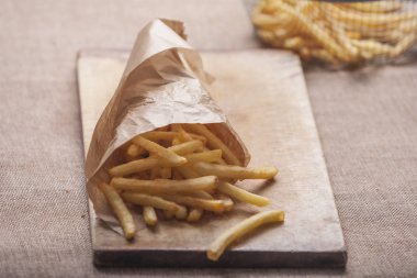 Tahta arka planda ketçaplı taze kızarmış patates kızartması.