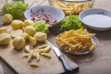 Tahta arka planda ketçaplı taze kızarmış patates kızartması.