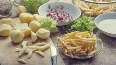 Tahta arka planda ketçaplı taze kızarmış patates kızartması.