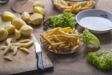 Tahta arka planda ketçaplı taze kızarmış patates kızartması.