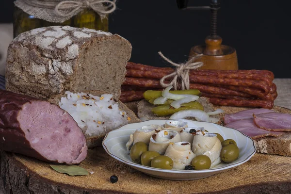 Natura morta con pane scuro, salsiccia e aringhe — Foto Stock