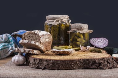 Turşu. Tuzlu salatalık natürmort karanlık ekmek ile