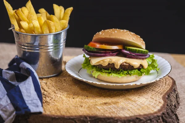 Fresh french fries, chips with tasty burger background