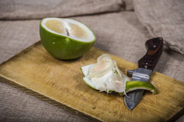 Toranja verde doce no fundo de madeira com faca — Fotografia de Stock