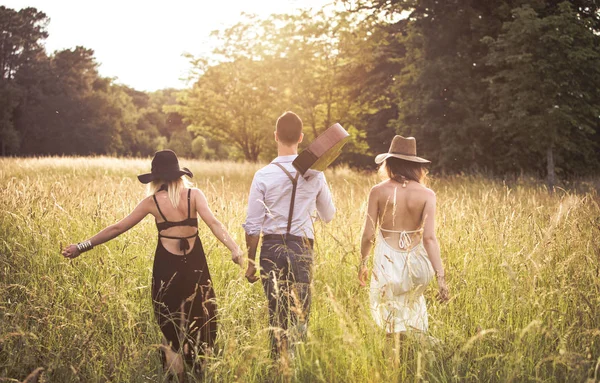 Group of young hipster walking in a field