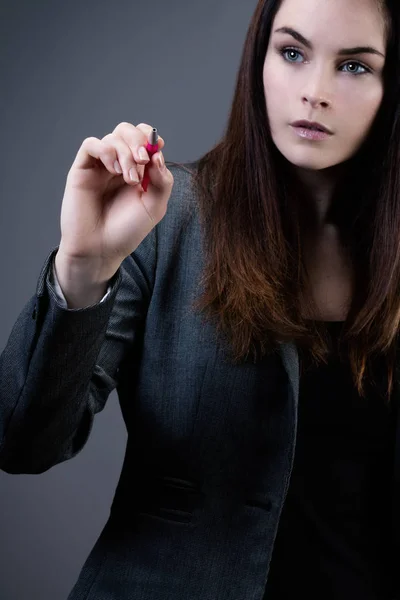 Portrait of a young businesswoman holding a pen in her hand