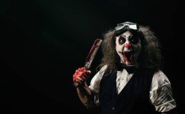 Portrait of a sadistic clown, a bloody knife in his hand clipart