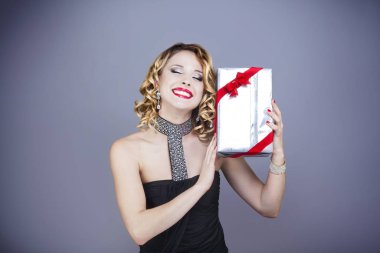 Portrait of a smiling young woman from the front, a gift in their hands clipart