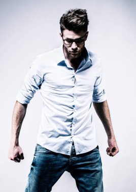 Young man standing in white shirt, facing front, clenched fists clipart