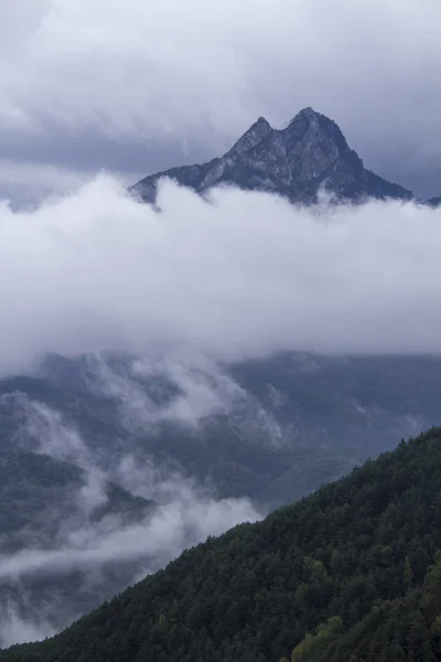 Gipfel ragt aus den tiefen Wolken. — Stockfoto