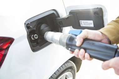 Adam arabasının deposunu sıkıştırılmış doğal gazla dolduruyor, GNC. Aracın hem benzin hem de benzin deposu var. Kavram Yenilenebilir Enerji, ekolojik araç.