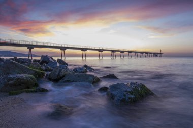 Pont del Petroli sahilinde ipeksi suyla gün doğumu.