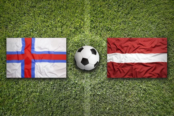 Фарерські острови проти Латвії прапори на футбольному полі — стокове фото