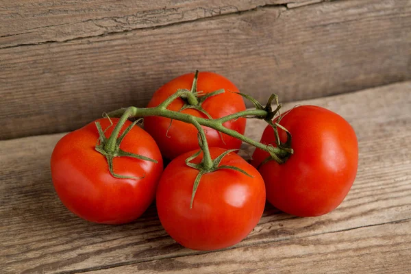 Tomates vermelhos em fundo de madeira — Fotografia de Stock