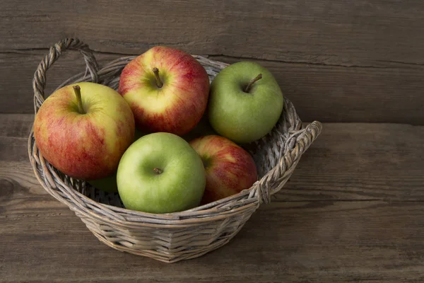 Korb mit frischen Äpfeln auf Holzgrund — Stockfoto