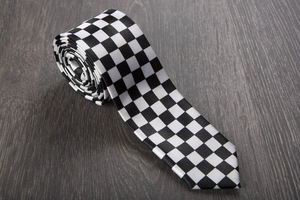 Svart och vit mönstrad slips på trä bakgrund — Stockfoto