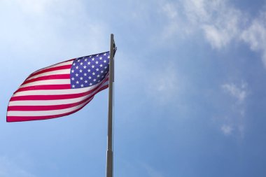 Bir bayrak direğine mavi gökyüzü önünde Amerika Birleşik Devletleri bayrağı