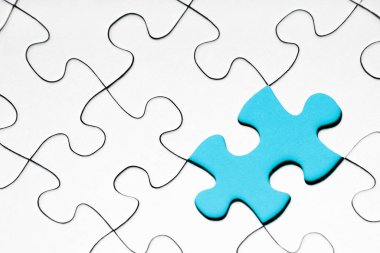 Beyaz yapboz parçaları arasında açık mavi yapboz parçası    