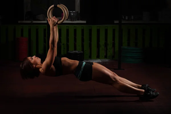 Ajuste mujer joven en anillos de gimnasta — Foto de Stock