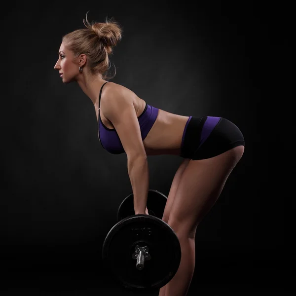 Muskulös tjej med en skivstång — Stockfoto