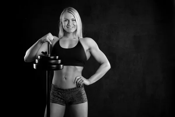 Girl with a barbell on black background — Stock Photo, Image