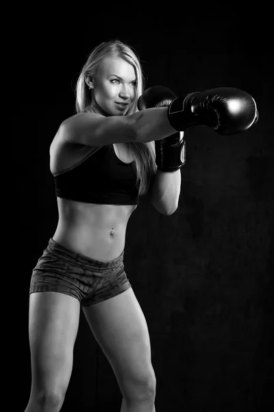 Девушка в боксёрских перчатках на черном фоне — стоковое фото