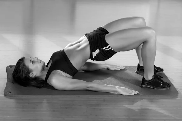 若い魅力的な女性の腹筋運動を行う — ストック写真