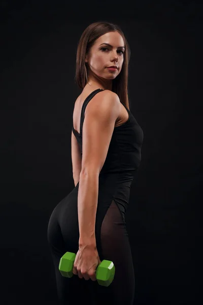 Спортивная мускулистая женщина работает с гантелями — стоковое фото