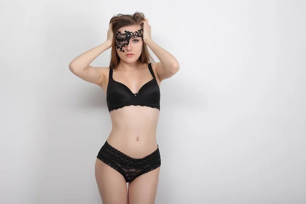 Junge Frau in schwarzer Dessous und Maske — Stockfoto