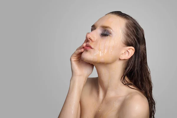 Beautiful woman with honey on her face — Stock Photo, Image