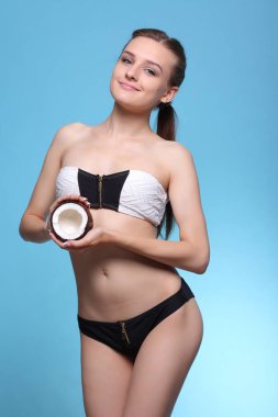 Hindistan cevizi yarısını tutan sevimli gülümseyen kız