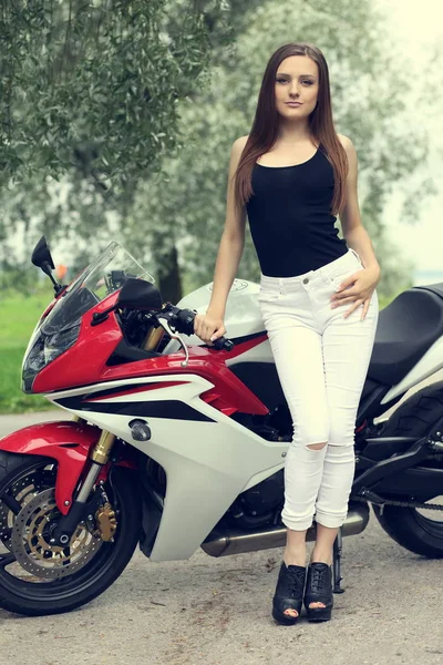 Chica joven con una motocicleta deportiva — Foto de Stock