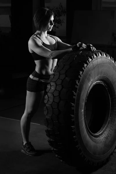 Ajuste atleta femenina realizando una voltereta de neumático —  Fotos de Stock