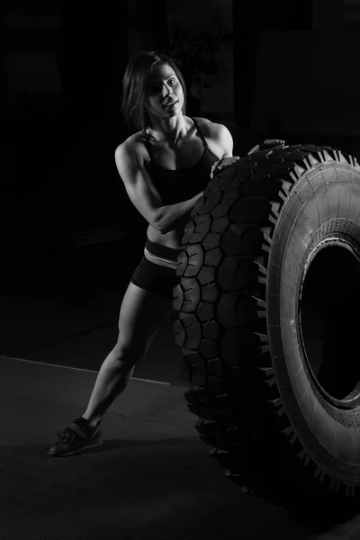 Ajuste atleta femenina realizando una voltereta de neumático — Foto de Stock