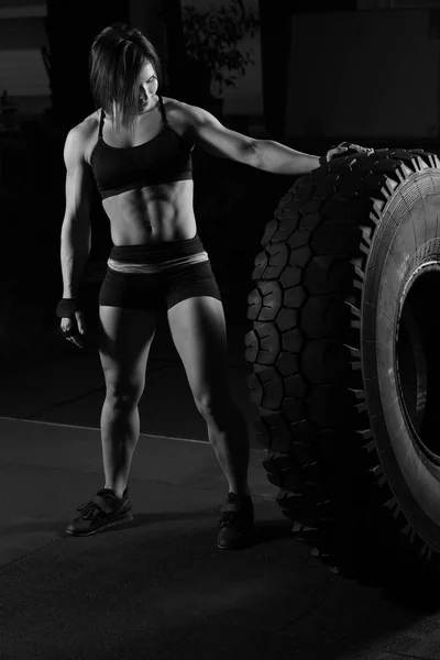 Ajuste atleta femenina realizando una voltereta de neumático —  Fotos de Stock