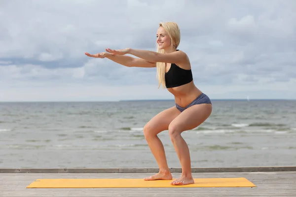 Donna che fa yoga al mare — Foto Stock