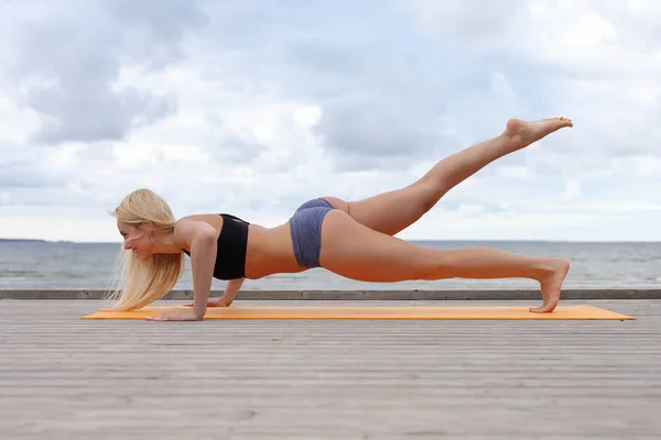 Donna che fa yoga al mare — Foto Stock