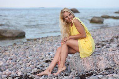 Sahilde sarı elbiseli sarışın kız